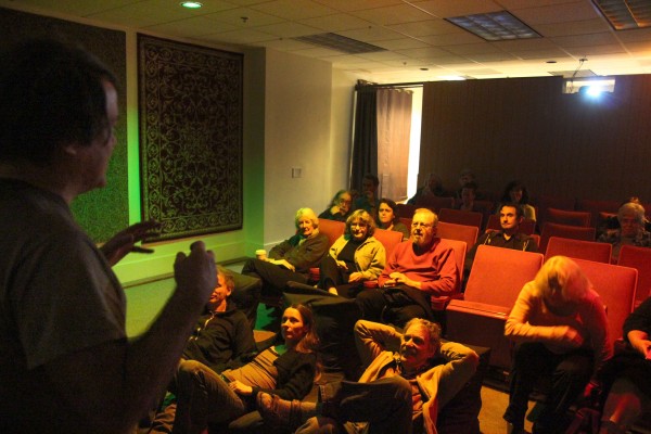 Ross Woodbury, left, speaks to a crowd gathered to watch a free screening of the 1947 film 'The Secret Life of Walter Mitty' at his one-screen art theater, The Magick Lantern. Woodbury opened the theater a year ago, but has struggled to find a regular audience. (Photo by: Kevin N. Hume)